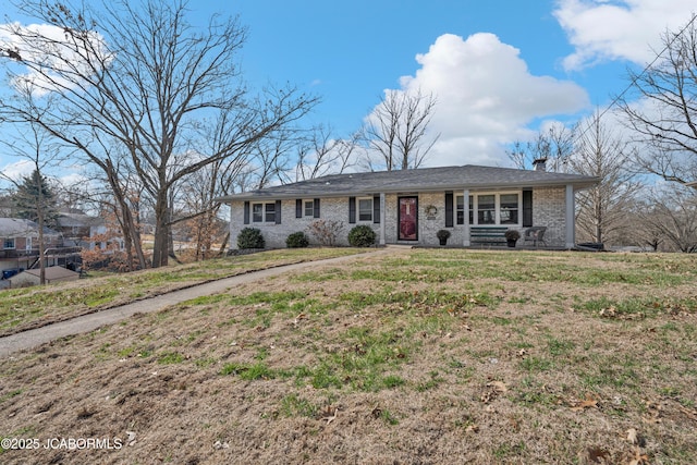 single story home featuring a front yard, brick siding, and a chimney