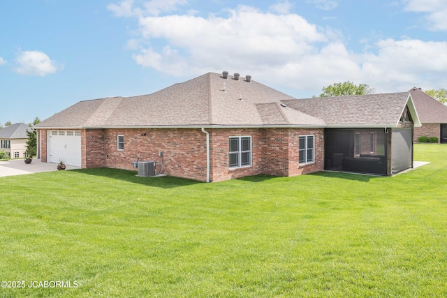 view of home's exterior featuring central air condition unit, a sunroom, a yard, and a shingled roof