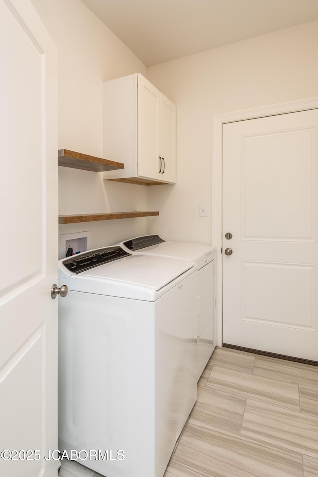 washroom with independent washer and dryer and cabinet space