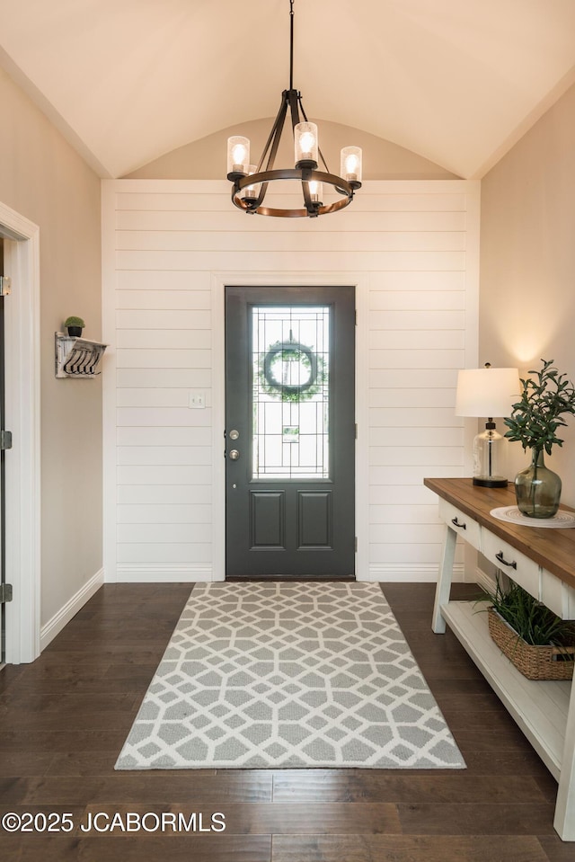 entrance foyer with lofted ceiling, dark wood-style floors, and a notable chandelier