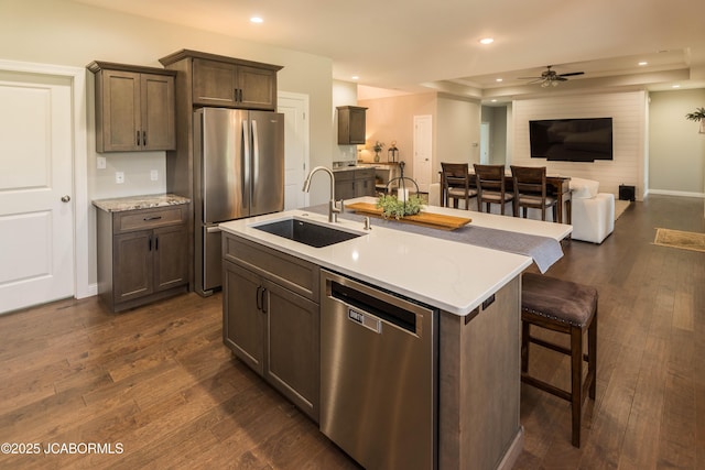 kitchen with a ceiling fan, a sink, open floor plan, stainless steel appliances, and recessed lighting