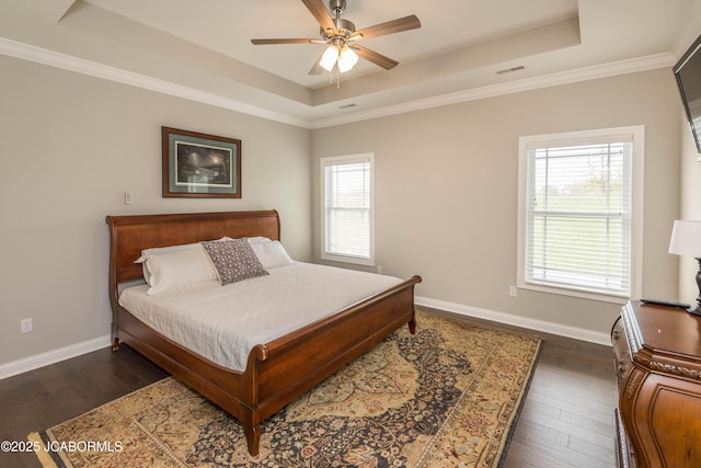 bedroom featuring baseboards, multiple windows, dark wood-style floors, and a raised ceiling