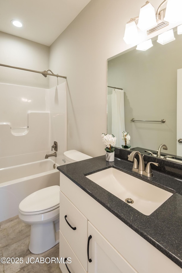 bathroom featuring shower / tub combo, toilet, and vanity