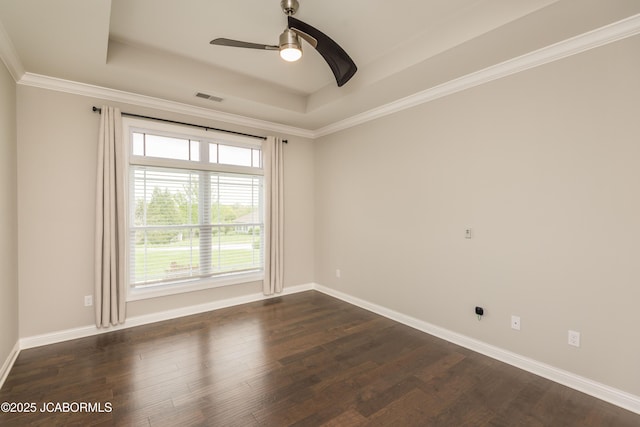 spare room with ceiling fan, dark wood-type flooring, visible vents, and a raised ceiling
