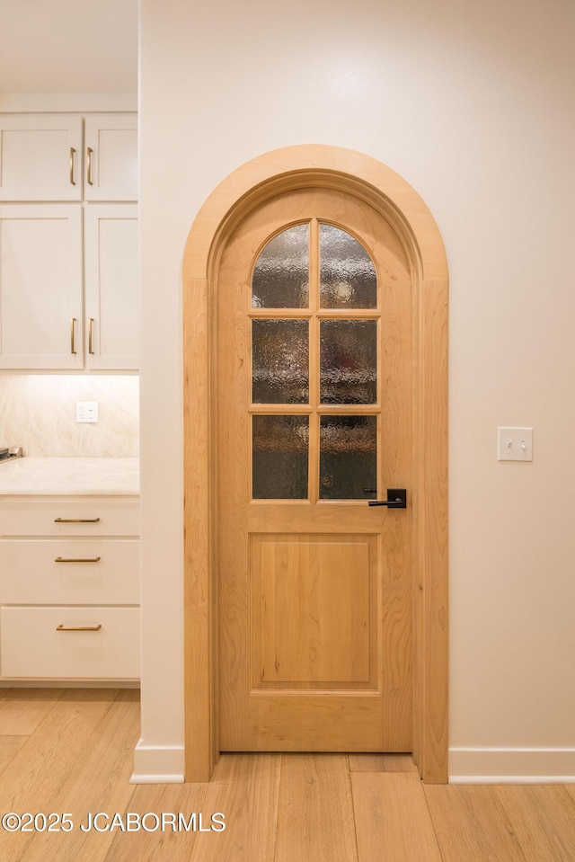 room details featuring arched walkways, wood finished floors, and baseboards