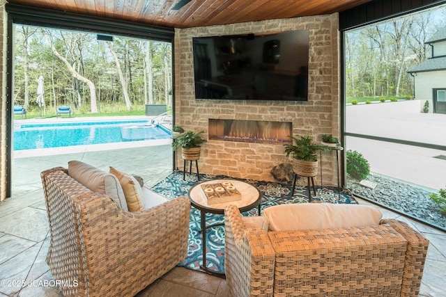 living room with an outdoor stone fireplace and wood ceiling