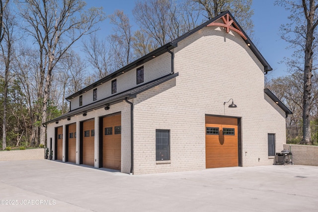 view of side of property featuring driveway and brick siding