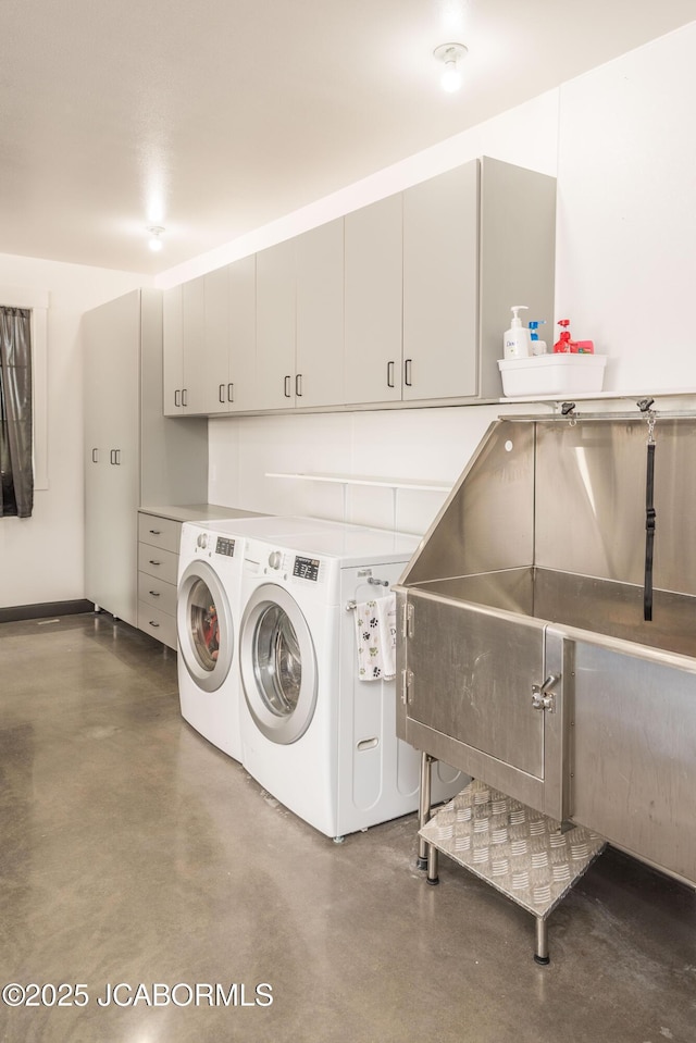 laundry area with washing machine and clothes dryer and cabinet space