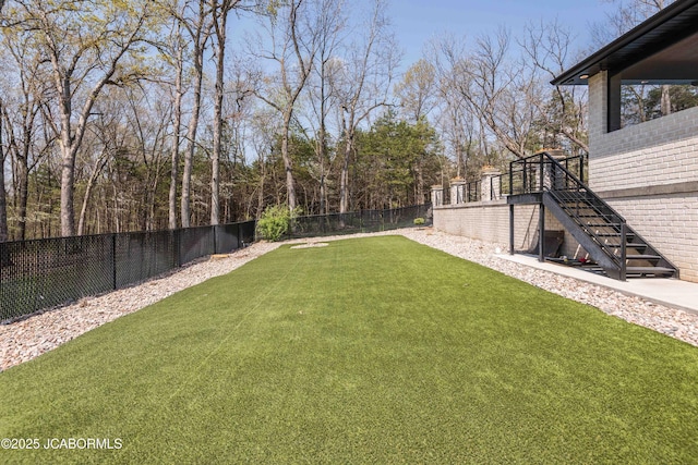 view of yard featuring stairway and a fenced backyard