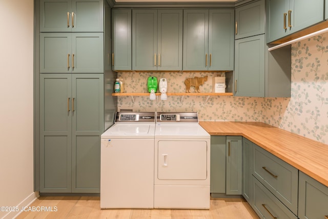 washroom featuring cabinet space, light wood-style flooring, and independent washer and dryer