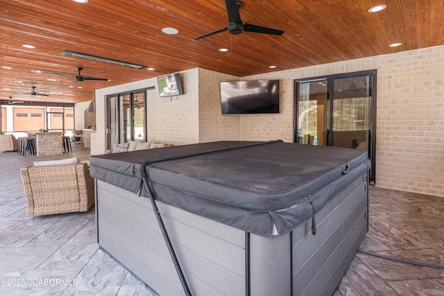 view of patio with a ceiling fan and an indoor hot tub
