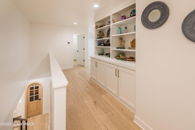 hallway featuring recessed lighting, light wood-style floors, and baseboards