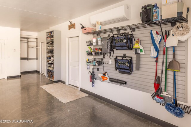 garage with baseboards and an AC wall unit