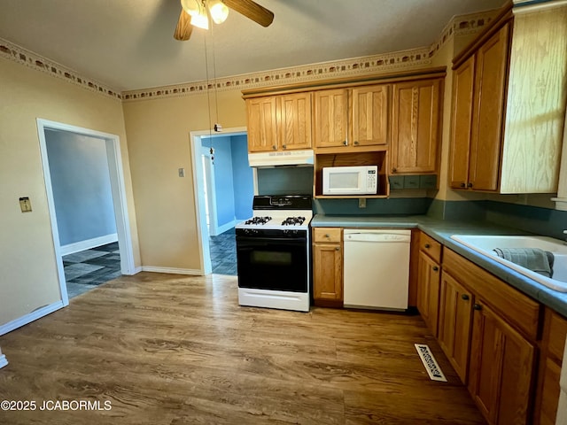 112 W 6th St, Fulton, MO 65251 - kitchen featuring white appliances, under cabinet range hood, a ceiling fan, wood finished floors, and a sink