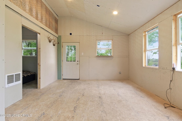 unfurnished room with visible vents, a wealth of natural light, and lofted ceiling