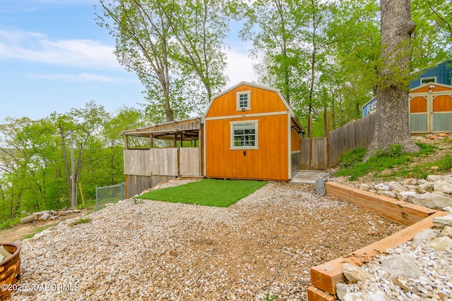 view of outbuilding featuring fence and an outbuilding