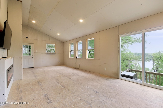unfurnished living room with recessed lighting, a water view, and lofted ceiling