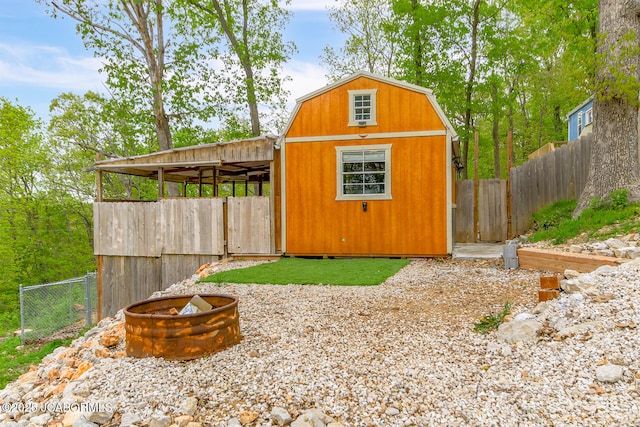 view of outdoor structure with fence and an outbuilding
