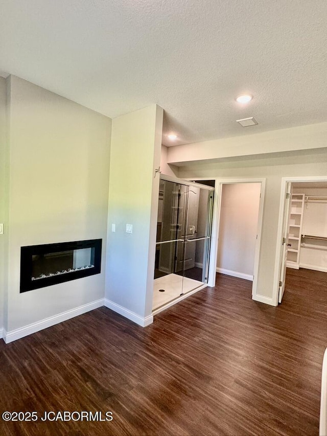 1680 W Fenton Rd, Columbia, MO 65202 - unfurnished living room featuring a textured ceiling, baseboards, wood finished floors, and a glass covered fireplace