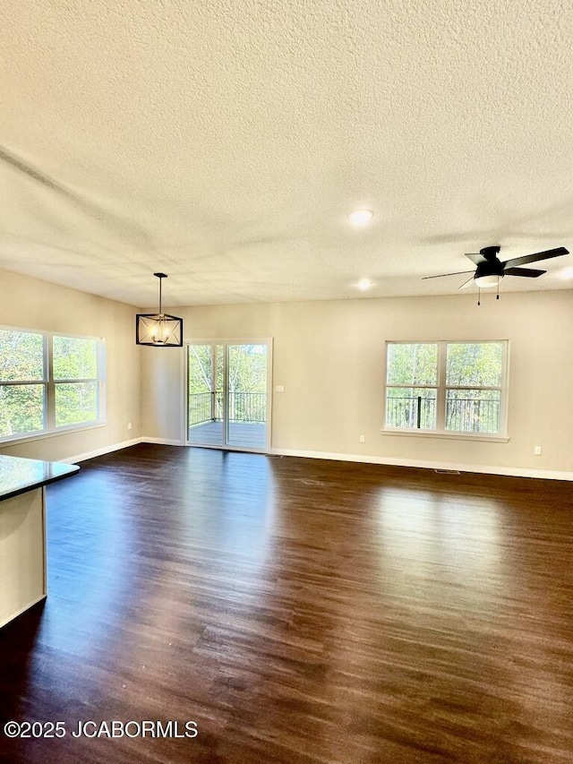 1680 W Fenton Rd, Columbia, MO 65202 - empty room featuring a textured ceiling, dark wood-style flooring, and a healthy amount of sunlight