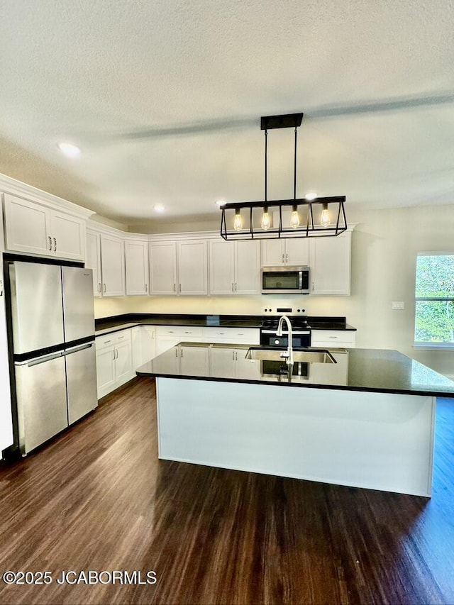 1680 W Fenton Rd, Columbia, MO 65202 - kitchen with dark wood-style floors, a sink, stainless steel appliances, white cabinetry, and dark countertops