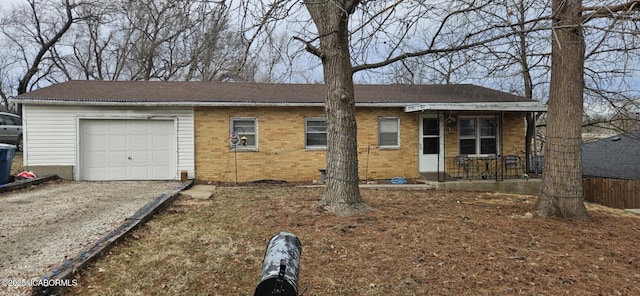 ranch-style home with a garage, driveway, a porch, and brick siding