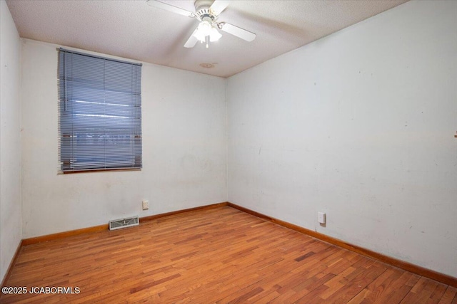 unfurnished room featuring ceiling fan, light hardwood / wood-style floors, and a textured ceiling