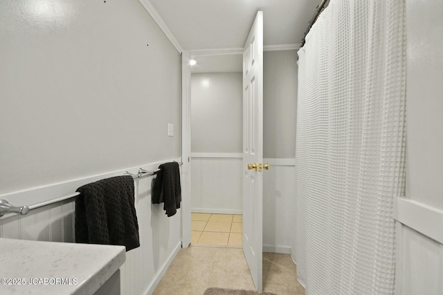 bathroom featuring tile patterned floors and a wainscoted wall