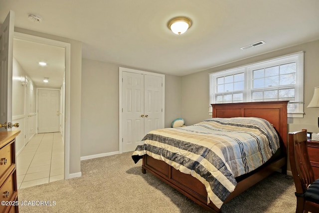 tiled bedroom featuring a closet, visible vents, baseboards, and carpet