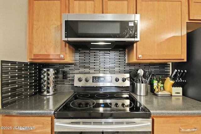 kitchen with stainless steel appliances, dark countertops, and decorative backsplash