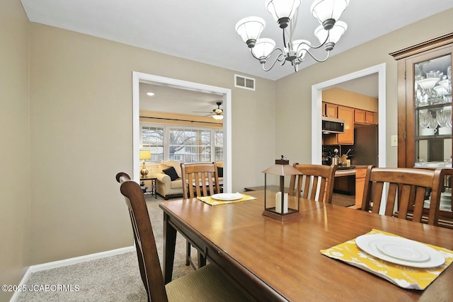 dining room featuring ceiling fan with notable chandelier, carpet flooring, baseboards, and visible vents