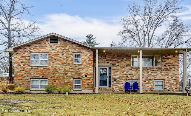 bi-level home featuring brick siding and a front lawn