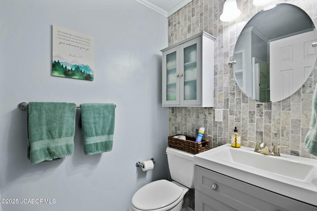 bathroom featuring decorative backsplash, toilet, vanity, and crown molding