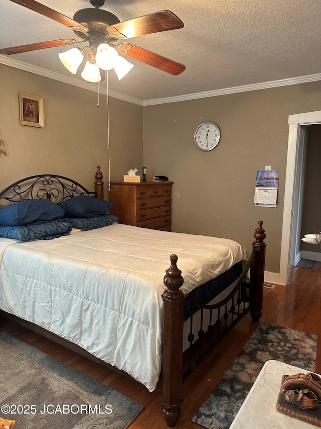 bedroom featuring dark wood-type flooring, ceiling fan, ornamental molding, and a textured ceiling