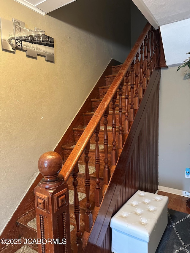 staircase with hardwood / wood-style floors