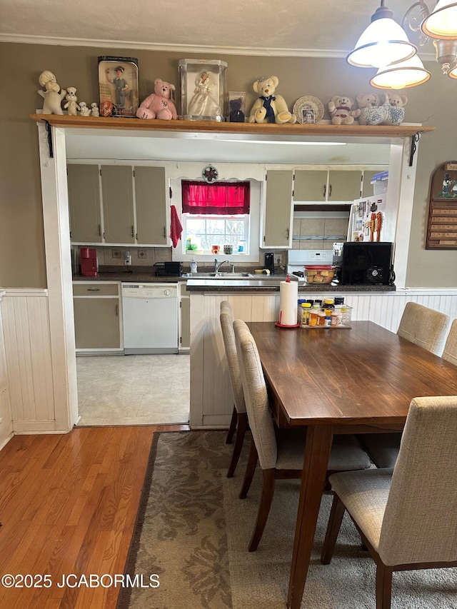 kitchen with sink, decorative light fixtures, dishwasher, and light wood-type flooring