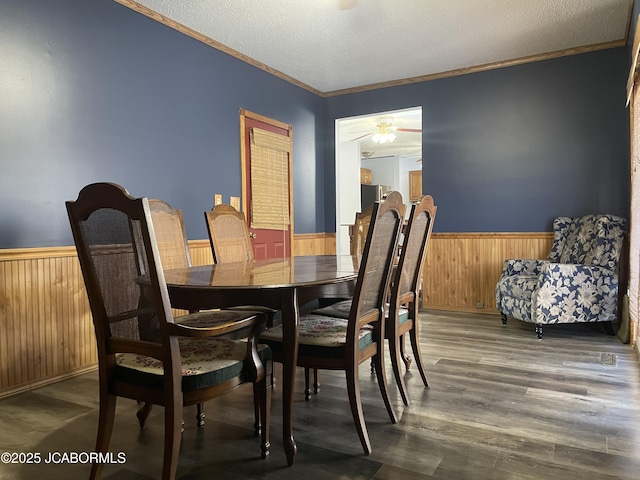 dining space featuring a textured ceiling, ceiling fan, ornamental molding, and dark hardwood / wood-style flooring