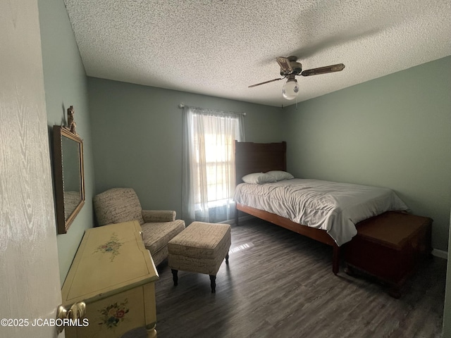 bedroom with a textured ceiling, ceiling fan, and dark hardwood / wood-style floors