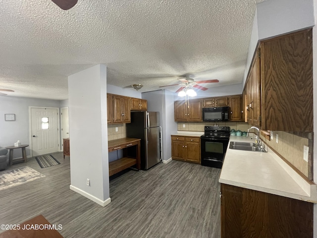 kitchen featuring a ceiling fan, light countertops, a sink, and black appliances