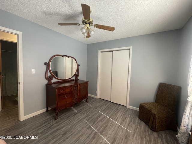 sitting room with ceiling fan, dark hardwood / wood-style floors, and a textured ceiling