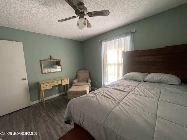 bedroom featuring dark wood-type flooring, a textured ceiling, and ceiling fan