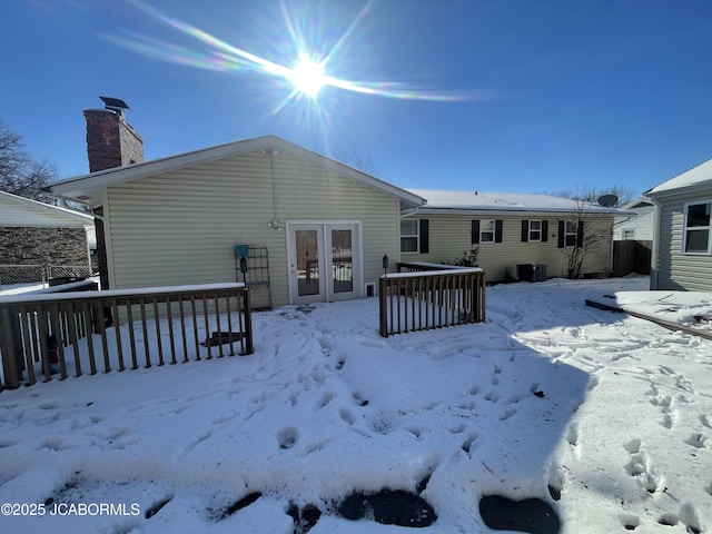 snow covered rear of property featuring cooling unit