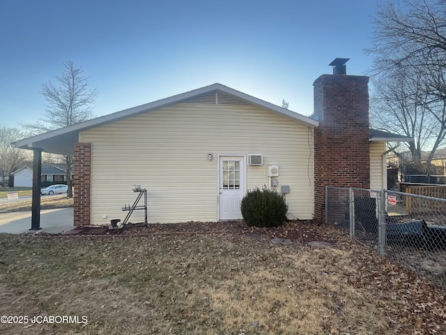 back of house featuring fence and a chimney