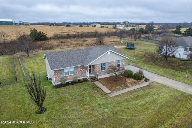 view of front of home featuring a rural view, a trampoline, and a front yard