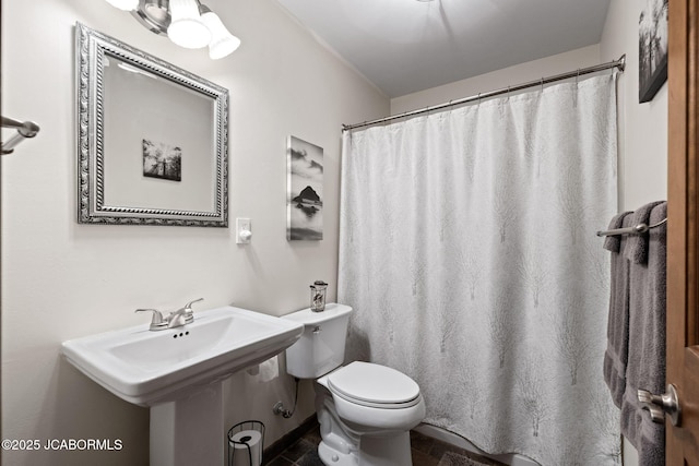 bathroom with curtained shower and toilet