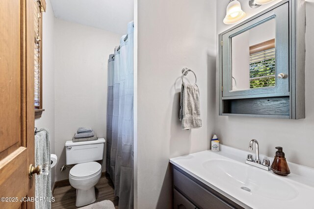 bathroom featuring vanity, a shower with curtain, toilet, and wood finished floors