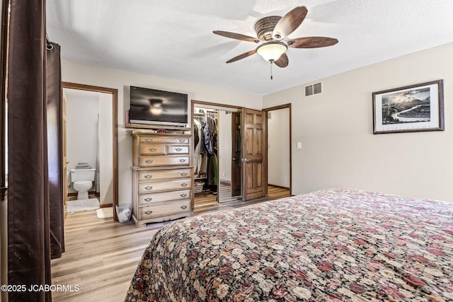 bedroom featuring a ceiling fan, visible vents, light wood-style flooring, a closet, and a textured ceiling