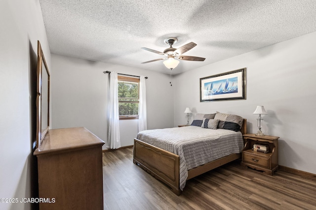 bedroom with a textured ceiling, dark wood-style floors, baseboards, and ceiling fan