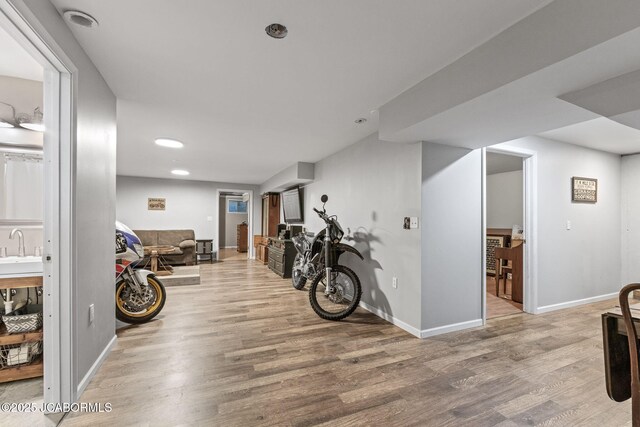 workout room with recessed lighting, baseboards, light wood-style floors, and a sink