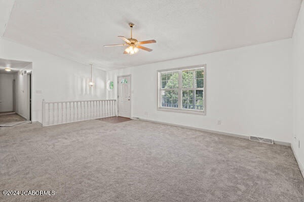 carpeted empty room with ceiling fan and lofted ceiling